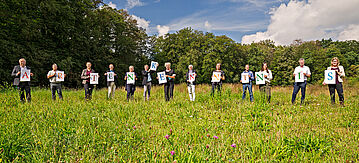 Setzen sich gemeinsam für die Förderung der Artenkenntnis ein: (von links nach rechts) Prof. Dr. Norbert Hölzel, Dr. Eick von Ruschkowski, Dr. Britta Linnemann, Norbert Blumenroth, Bundesumweltministerin Svenja Schulze, Dr. Christian Göcking, BfN-Präsidentin Prof. Dr. Beate Jessel, Dr. Heinrich Terlutter, Karoline Luther, Prof. Dr. Christoph Scherber, Dr. Hannah Reininghaus, Prof. Dr. Bernhard Misof, Claudia Knauft-Pieper. Alle stehen auf einer Wiese und halten einen Buchstaben hoch, zusammen ergibt es das Wort Artenkenntnis.