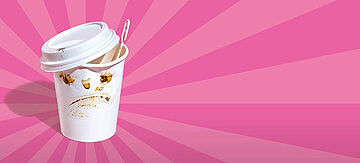 Kampagnenmotiv Coffee to go-Becher vor rosa Hintergrund