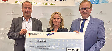 Thomas Gruschka, Kreistagsvorsitzender, Bundesumweltministerin Steffi Lemke und Landrat Markus Bauer bei der Übergabe des Fördermittelbescheids im Kreistagssitzungssaal in Bernburg.