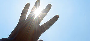 Hand schützend vor die Sonne gehalten.