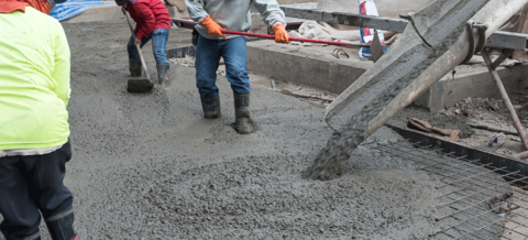 Arbeiter auf der Baustelle beim Verlegen der Betonplatte