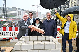 Herr Flasbarth, Frau Petra Wesseler und Prof. Alexander von Erdély halten gemeinsam eine Zeitkapsel.