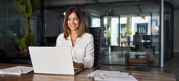 Erfahrene Mitarbeiterin am Laptop. 