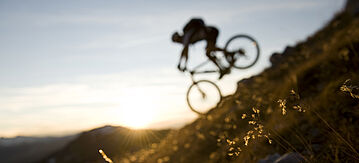 Person auf einem Mountainbike in der Natur auf einem Hügel