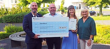 Vier Personen halten Förderbescheid