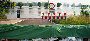 Der Blick von einer Straßensperrung auf ein vom Hochwasser betroffenes Gebiet.