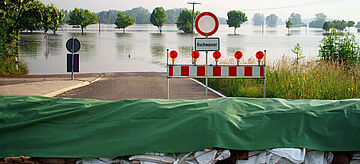 Der Blick von einer Straßensperrung auf ein vom Hochwasser betroffenes Gebiet.