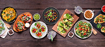 Verschiedene gesunde pflanzliche Gerichte, Draufsicht auf dunklem Holzbannerhintergrund.