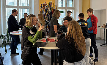 Beteiligte diskutieren am Stehtisch