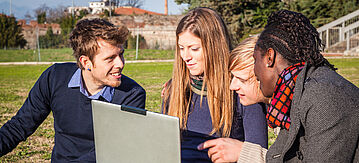 Studenten mit Laptop sitzen im Park