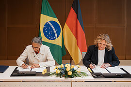 Steffi Lemke und Marina Silva unterschreiben ein Dokument.