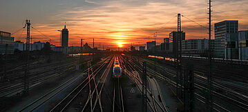 Sonnenuntergang auf der Eisenbahn und der Bahnhof