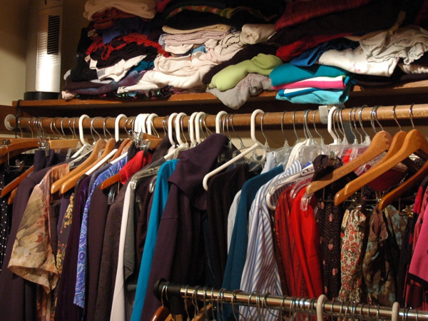 Kleiderstange mit aufgehängten bunten Klamotten.