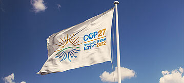 Weiße Flagge mit COP27-Logo im Wind
