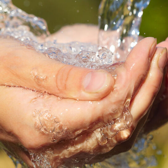 Wasser fließt in eine Hand