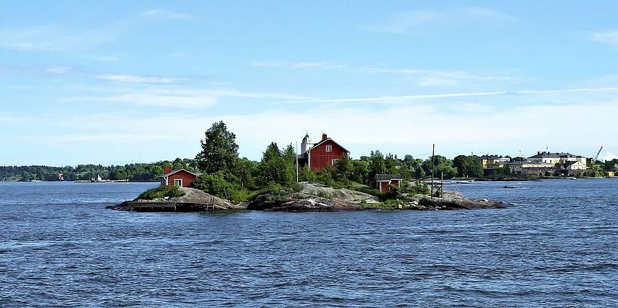 Kleines rotes Holzhaus auf einer Insel.