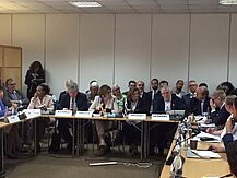 Menschen sitzen an Tischen und diskutieren