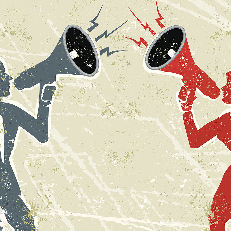 Zwei Menschen schreien durch ein Megafon.