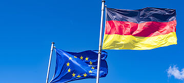 Flaggen von Deutschland und der EU wehen im Wind