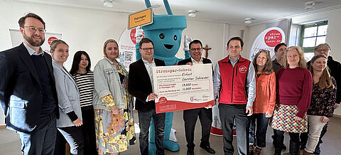 Gruppenbild mit Maskottchen Stecky: Carsten Schneider überreicht Förderscheck