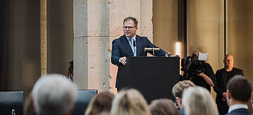 Carsten Schneider, Bundesumweltminister hält eine Rede auf der Bühne