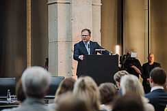 Carsten Schneider, Bundesumweltminister hält eine Rede auf der Bühne