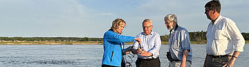 4 Personen stehen im Wasser: Bundesumweltministerin Steffi Lemke, Umweltminister Till Backhaus (Mecklenburg-Vorpommern) und Axel Vogel (Brandenburg) sowie Dirk Treichel vom Nationalpark Unteres Odertal 