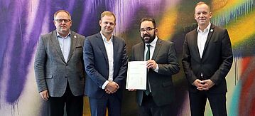 Übergabe einer Klimakonzeptstudie an den Parlamentarischen Staatssekretär Christian Kühn, die aufzeigt, wie anspruchsvoller Klimaschutz bei einer Sportgroßveranstaltung wie der Fußball-Europameisterschaft der Herren 2024 in Deutschland (UEFA EURO 2024) organisiert werden kann. Das BMUV hat die Studie in Auftrag gegeben und über den Ressortforschungsplan finanziert. V.l.n.r.: Mex Schär (GF EURO 2024 GmbH), Jan Peter Schemmel (Sprecher der Geschäftsführung des Öko-Instituts), Christian Kühn und Markus Stenger (GF Euro 2024 GmbH)