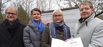 Dr. Bettina Hoffmann übergibt einen Förderscheck im Kurpark Bad Sulza an Bürgermeister Dirk Schütze