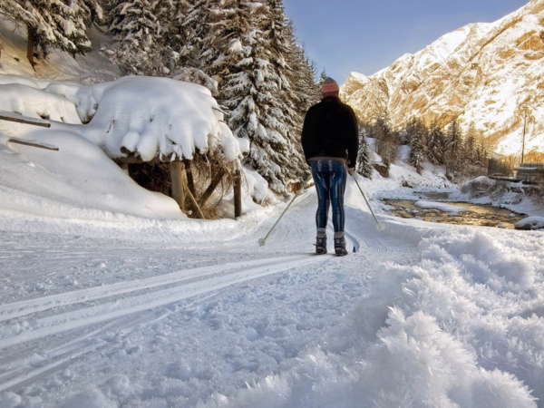 Ein Langläufer in einer sonnigen Schneelandschaft