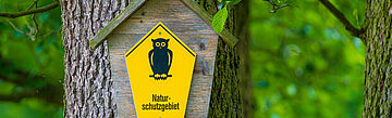 Schild für Naturschutzgebiet: Gelber Hintergrund mit dem Bild einer Eule