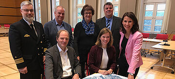 Gruppenfoto: Von links nach rechts: Stehend: Fregattenkapitän Alexander Stark, Bauausschussvorsitzender Detlef Schön, stellvertretende Umweltausschussvorsitzende Petra Stomberg, Oberbürgermeister Carsten Feist, Parlamentarische Staatssekretärin Rita Schwarzelühr-Sutter, Sitzend: Stadtbaurat Oliver Leinert, Bundestagsabgeordnete Siemtje Möller