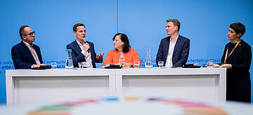 Diskussion auf dem Podium. Weitere Informationen siehe Bildunterschrift