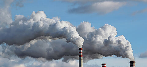 Himmel mit Schornstein einer Fabrik im Vordergrund