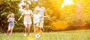Familie spielt Fußball im Garten