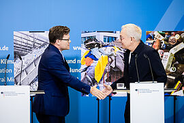 Bundesumweltminister Carsten Schneider (l) und Reiner Sojka, Gründer und Geschäftsführer eines Unternehmens für Batterierecycling,  bei der Pressekonferenz zur Präsentation des Aktionsprogramms zur Nationalen Kreislaufwirtschaftsstrategie (NKWS) im BMUKN Berlin