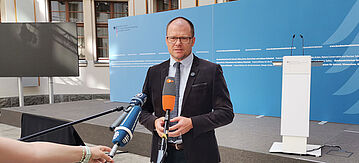 Bundesumweltminister Schneider wird von den Medien befragt.