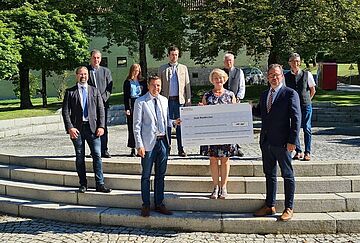 Der Parlamentarische Staatssekretär im BMU, Florian Pronold, überreicht einen Förderscheck an Vertreter der Gemeinde Waldkirchen