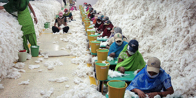 Arbeiterinnen und Arbeiter in einer Baumwollfabrik