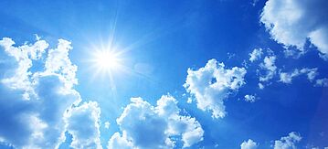 Blauer Himmel mit Wolken und Sonne