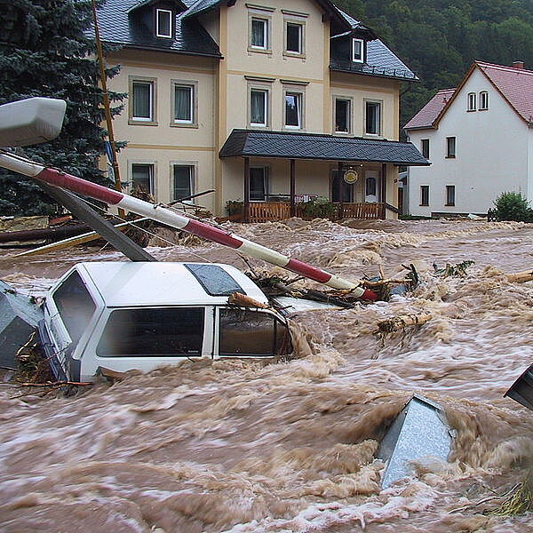 Flutwelle reißt Autos und andere Dinge mit.