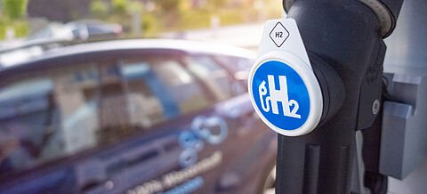 Ein Auto steht bei einer Wasserstofftankstelle 