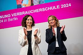 Steffi Lemke und Ramona Pop klatschen auf dem Podium.