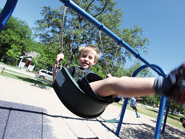 Kind schaukelt lächelnd