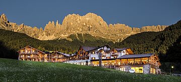 Abbildung des Hotel Cyprianerhof vor einem Alpenpanorama in der Abendsonne