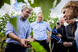 Winzer Jochen Schmitt stellt Bundesumweltminister Schneider das Weingut vor.