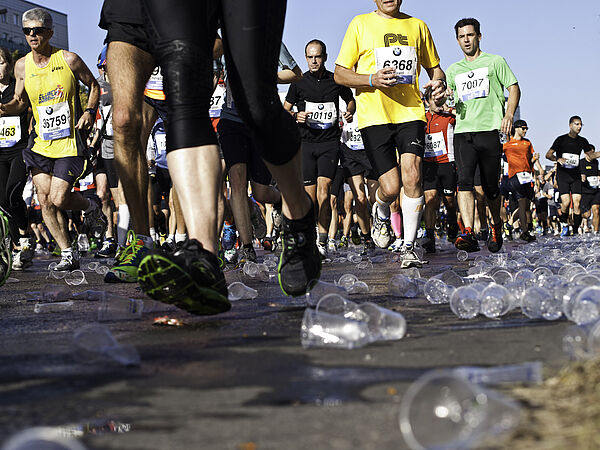 Jogger laufen auf Plastikbechern