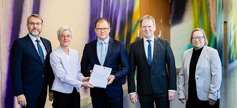 Bundesumweltminister Carsten Schneider (M) nimmt das Gutachten des Expertenrats für Klimafragen entgegen.