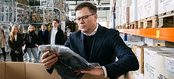 Carsten Schneider begutachtet Altkleidung 