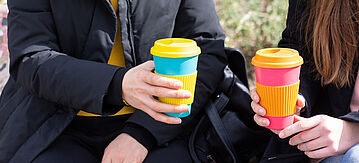 Zwei Mädchen mit Mehrweg-Kaffeebechern